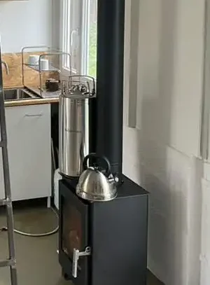 Douche solaire en inox Autumn'Home qui chauffe sur un poêle à bois