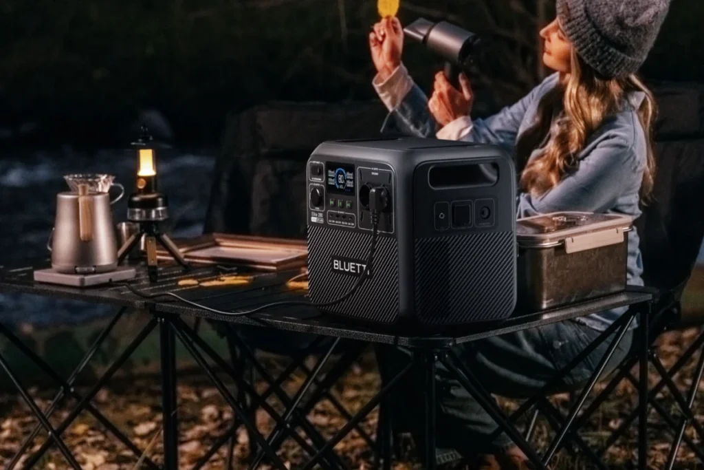 Station électrique BLUETTI alimentant une lampe en bivouac, le soir