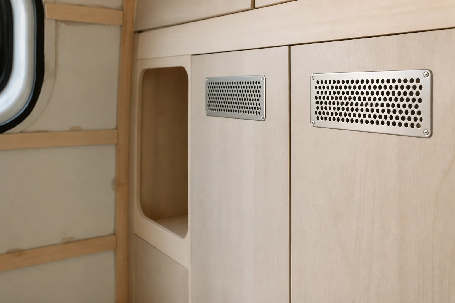 Grille d’aération posée dans la porte d’un placard de van aménagé