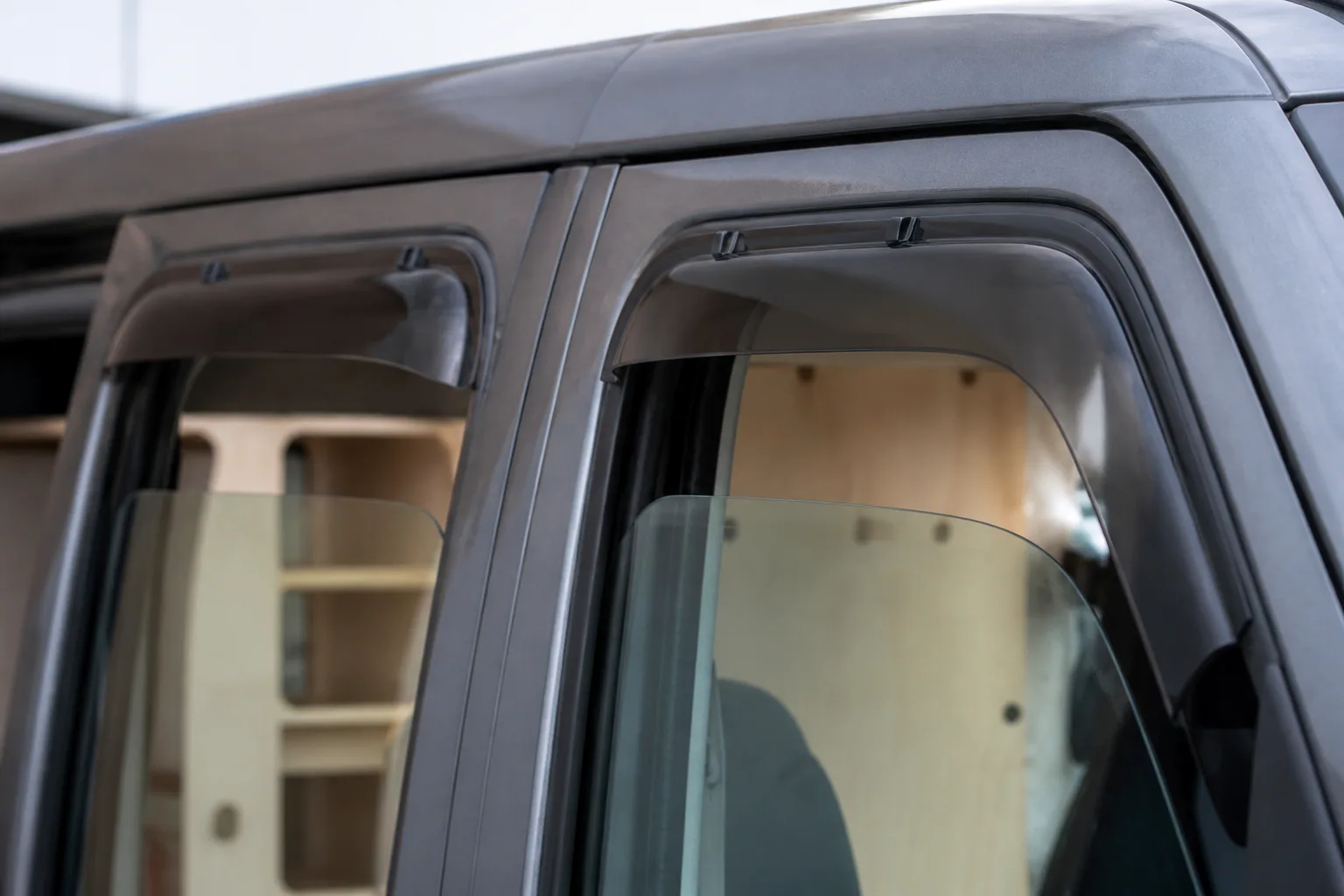 Déflecteur de portière posé sur la vitre d’un van aménagé pour aérer sans percer